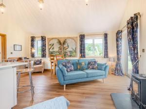 a living room with a blue couch and a table at Violet Cottage in Hereford