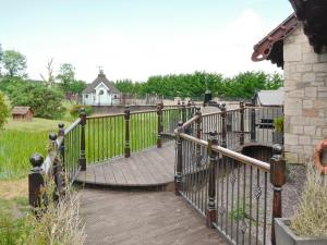 a wooden walkway with a gate in front of a house at Tennox Boathouse - Ukc4438 in Kilbirnie +14 photos