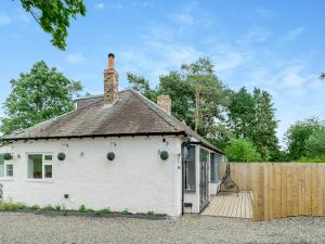 a small white house with a wooden fence at Vallum Villa - Uk40231 in Bardon Mill