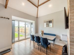 a dining room with a table and blue chairs at Vallum Villa - Uk40231 in Bardon Mill