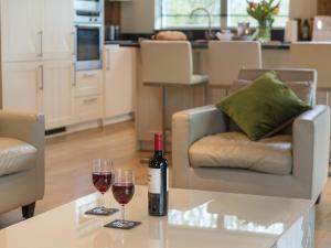 a bottle of wine and two glasses on a table at Coot Lodge in Somerford Keynes