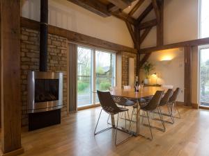 a dining room with a table and chairs and a television at Coot Lodge in Somerford Keynes