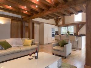 a living room with a couch and a table at Coot Lodge in Somerford Keynes +16 photos