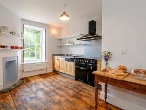a kitchen with a black stove and a wooden floor at Colveston Manor in Cranwich