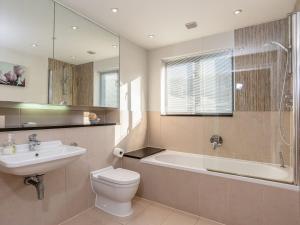 a bathroom with a sink and a toilet and a bath tub at Sand Dunes in Westward Ho
