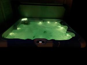 a green bath tub in a dark room at The Lodge - Uk13202 in Cayton