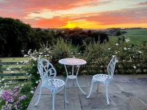 a table and two chairs with a table and a sunset at The Cwtch - Os7 in Newtown