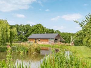 a log cabin with a pond in front of it at The Cwtch - Os7 in Newtown +17 photos