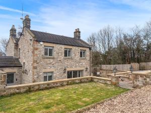an old stone house with a garden in front of it at Ghyll Cottage - Uk51667 in Leyburn