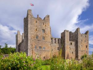 a castle with a flag on top of it at Ghyll Cottage - Uk51667 in Leyburn +25 photos