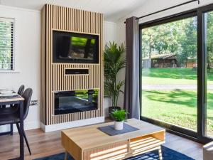 a living room with a fireplace and a tv at Willow Lodge in Ingleton