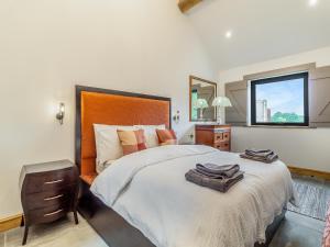 a bedroom with a large bed and a window at Loch Farm Stables in Watton