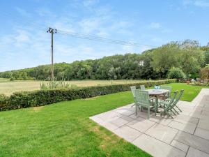 a patio with a table and chairs in the grass at Loch Farm Stables in Watton