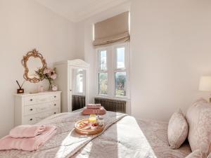a bedroom with a bed with a tray with a candle on it at West House in Wooler