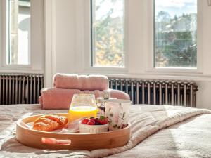a tray of breakfast foods and orange juice on a bed at West House in Wooler
