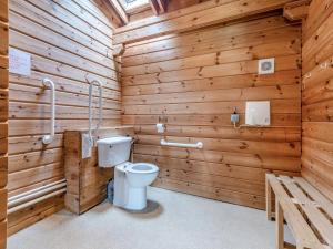 a bathroom with a toilet in a wooden wall at Lodge - Uk49989 in Blandford Forum