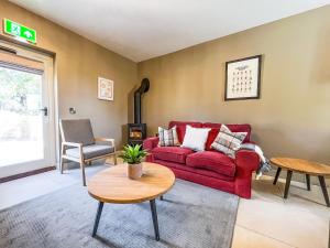 a living room with a red couch and a table at Stables - Uk51829 in Great Ayton