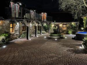 a courtyard at night with a walkway and lights at Tennox Stables - Uk39975 in Kilbirnie