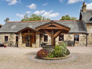a large stone building with a large wooden building at Tennox Stables - Uk39975 in Kilbirnie +9 photos