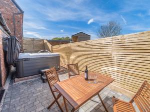 a patio with a wooden fence and a table and a tub at Corley Rocks Barn - Uk45939 in Corley