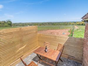 a wooden patio with a wooden table and chairs at Corley Rocks Barn - Uk45939 in Corley