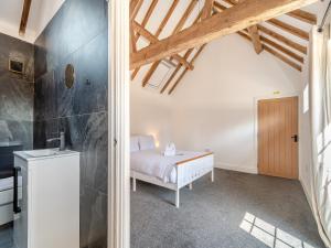 a bedroom with a white bed in a room at Corley Rocks Barn - Uk45939 in Corley