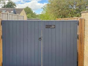 a blue gate with a sign on top of it at The Spinney in Carterton