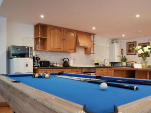 a kitchen with a pool table in a kitchen at The Spinney in Carterton