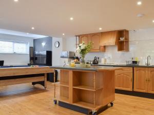 a kitchen with wooden cabinets and a island with flowers on it at The Spinney in Carterton