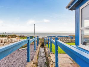 a blue house with a view of the ocean at Roggle Roich in Hilton of Cadboll
