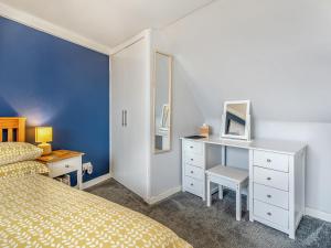 a bedroom with a bed and a desk with a mirror at Roggle Roich in Hilton of Cadboll +16 photos