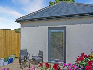a patio with chairs and flowers in front of a house at Trig View - Uk49915 in Bardon Mill