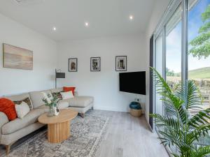 a living room with a couch and a tv at Trig View - Uk49915 in Bardon Mill