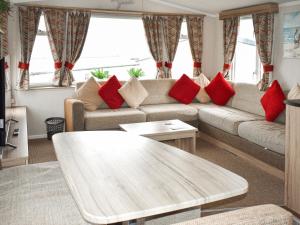 a living room with a couch and red pillows at Elms 116 - Ukc9403 in Exmouth