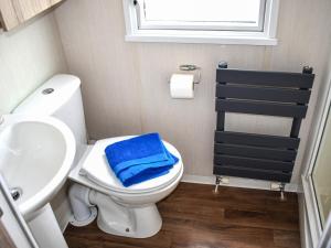 a bathroom with a toilet and a sink and a blue towel at Elms 116 - Ukc9403 in Exmouth
