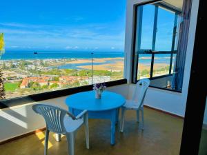 a table and chairs in a room with a view of the ocean at Appartement LE SABLE Uniquement les familles in Oualidia +24 photos