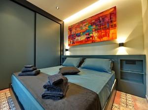 a bedroom with two beds and a painting on the wall at Mira Suite in Vietri sul Mare +42 photos