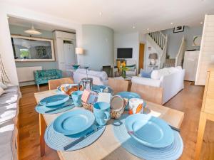 a living room with a table with blue plates on it at Dolphins Reach in Saint Mawes