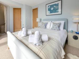 a bedroom with a large white bed with towels on it at Dolphins Reach in Saint Mawes +14 photos