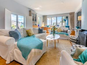 a living room with white couches and a table at Dolphins Reach in Saint Mawes