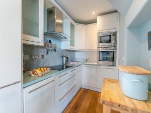 a kitchen with white cabinets and a bowl of fruit at Dolphins Reach in Saint Mawes