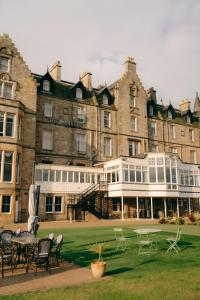 a large building with tables and chairs in front of it at Marine North Berwick in North Berwick