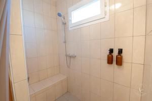 a shower with a window and two bottles on the wall at Maison Le Damier - Proche Center Parcs et Lamotte Beuvron - 3 chambres in La Ferté-Saint-Aubin +26 photos