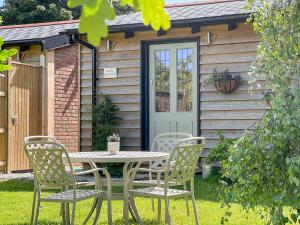 a table and chairs in front of a cabin at Bluebell Lodge-Uk32958 in Molash
