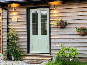 a door on the side of a house with plants at Bluebell Lodge-Uk32958 in Molash