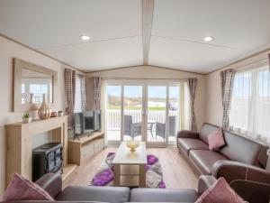 a living room with a couch and a tv at Hallcroft Fishery in Retford