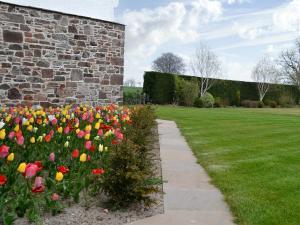 a garden with colorful flowers next to a brick wall at Grieve's Cottage - Uk11107 in Montrose