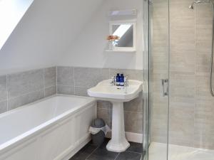 a bathroom with a tub and a sink and a shower at Grieve's Cottage - Uk11107 in Montrose