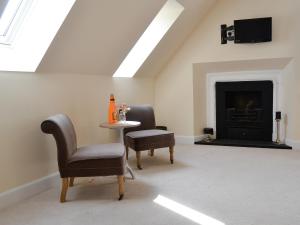 a room with two chairs and a table and a fireplace at Grieve's Cottage - Uk11107 in Montrose +10 photos