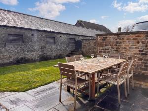 a wooden table with chairs and wine glasses at Stable Cottage - Uk51669 in Leyburn